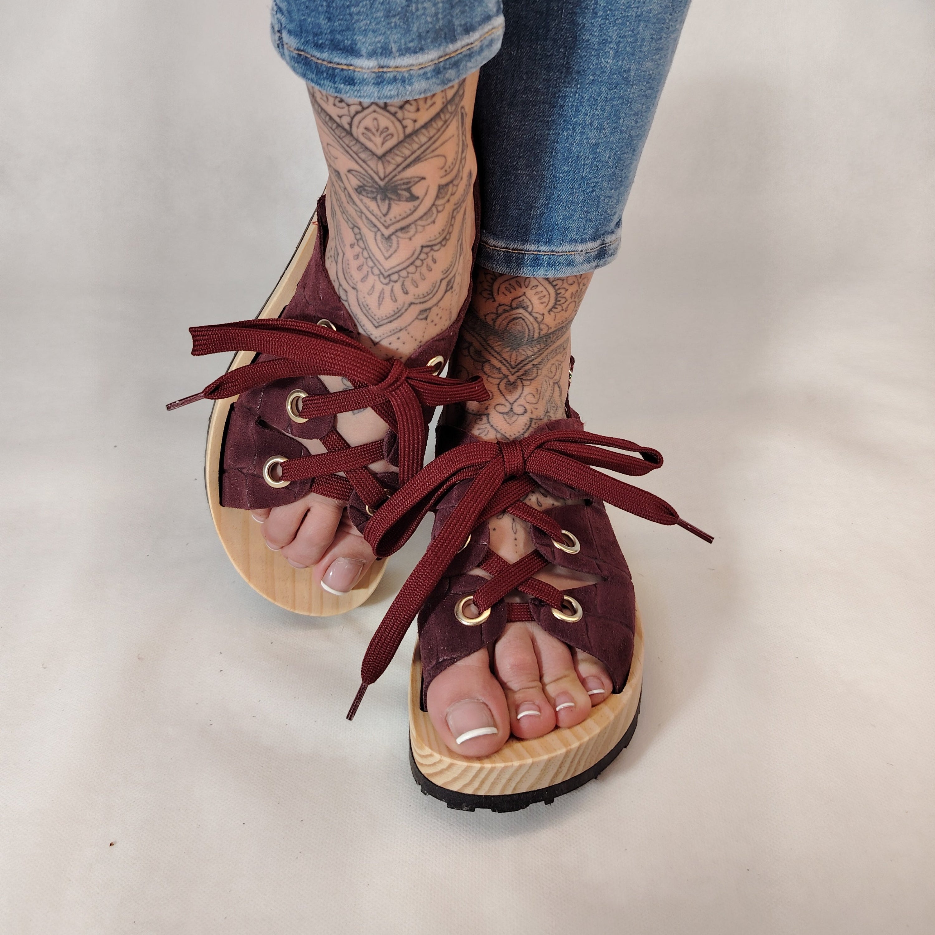 Sandalias de plataforma de madera natural artesanal con tira trasera y pala de piel efecto croco color burdeos y cordones 