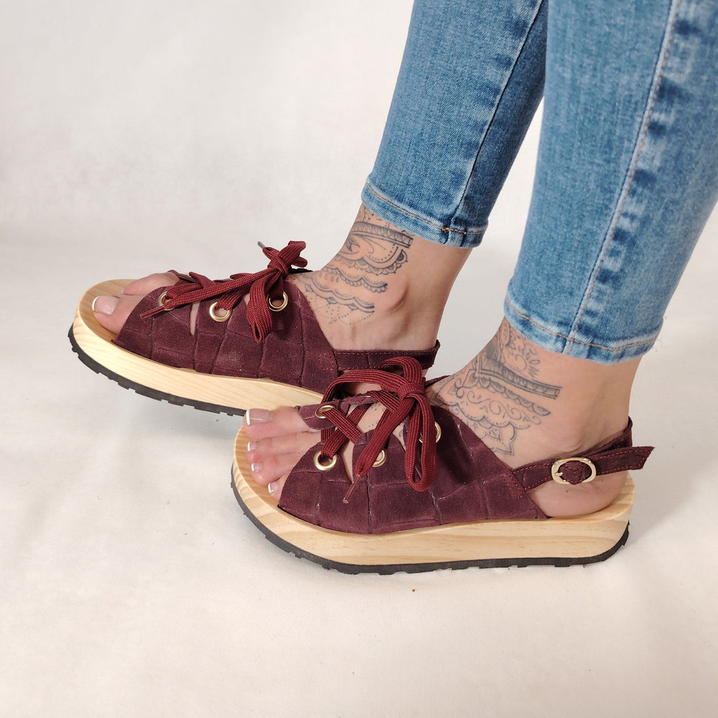 Sandalias de plataforma de madera natural artesanal con tira trasera y pala de piel efecto croco color burdeos y cordones 