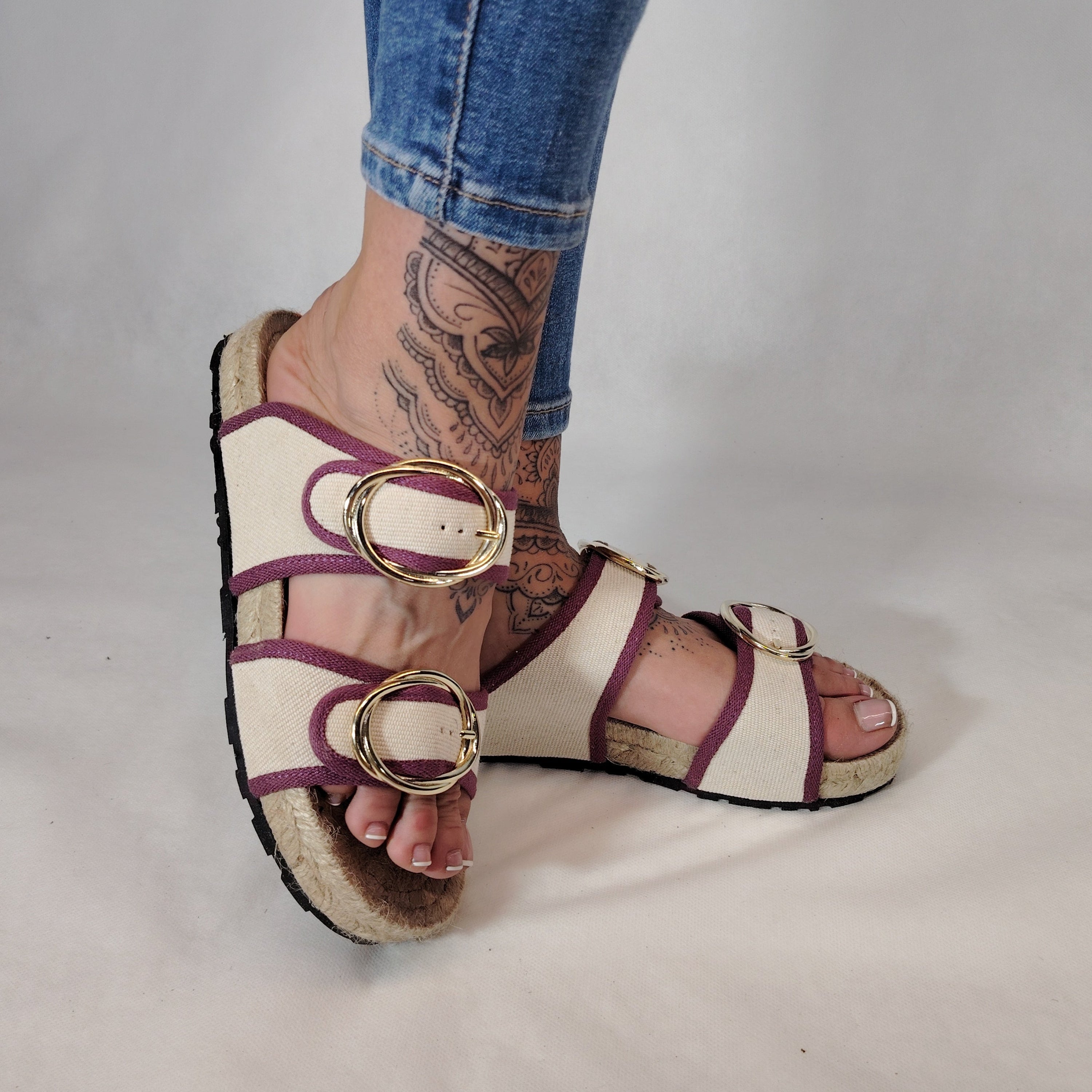 Sandalia plana de yute natural con corte en tejido color blanco y detalles en lila con 2 hebillas y diseño artesanal de verano.