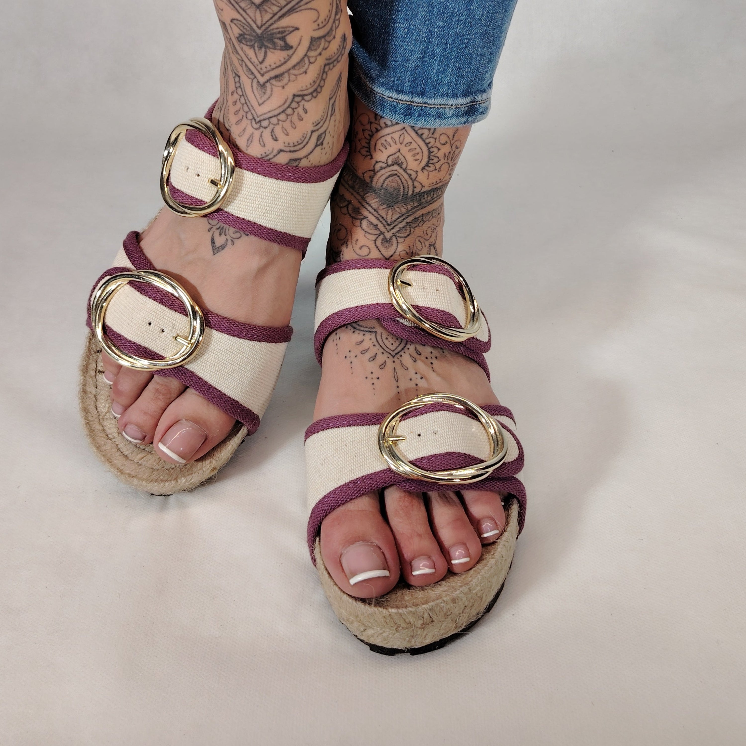 Sandalia plana de yute natural con corte en tejido color blanco y detalles en lila con 2 hebillas y diseño artesanal de verano.