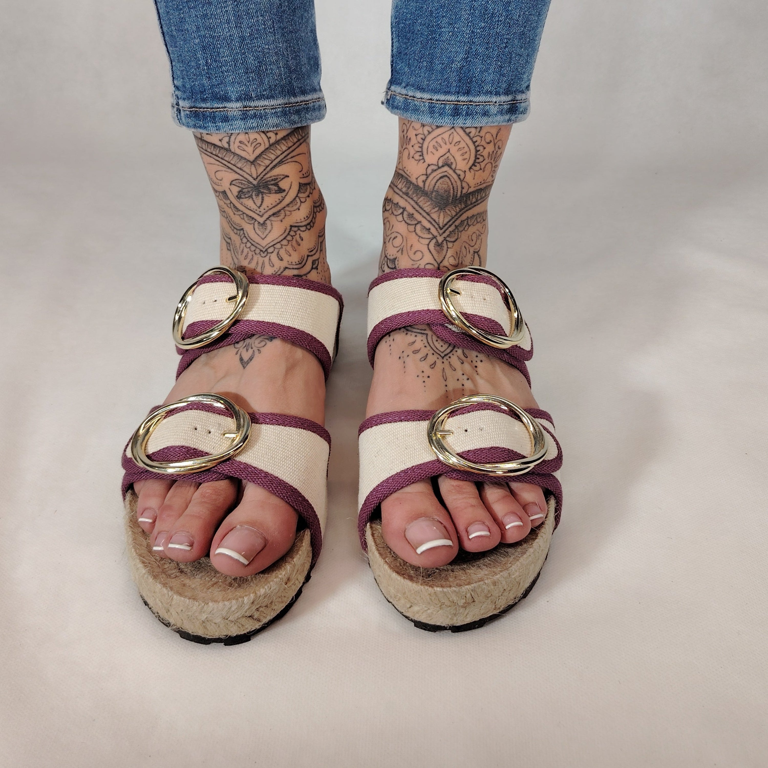Sandalia plana de yute natural con corte en tejido color blanco y detalles en lila con 2 hebillas y diseño artesanal de verano.