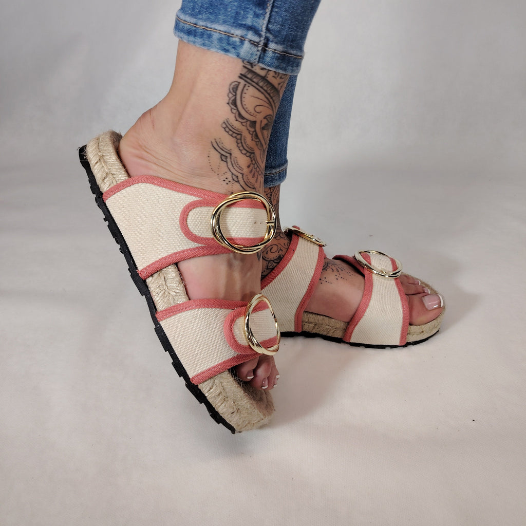 Sandalia plana de yute natural con corte en tejido color blanco y detalles en rosa con 2 hebillas y diseño artesanal de verano.