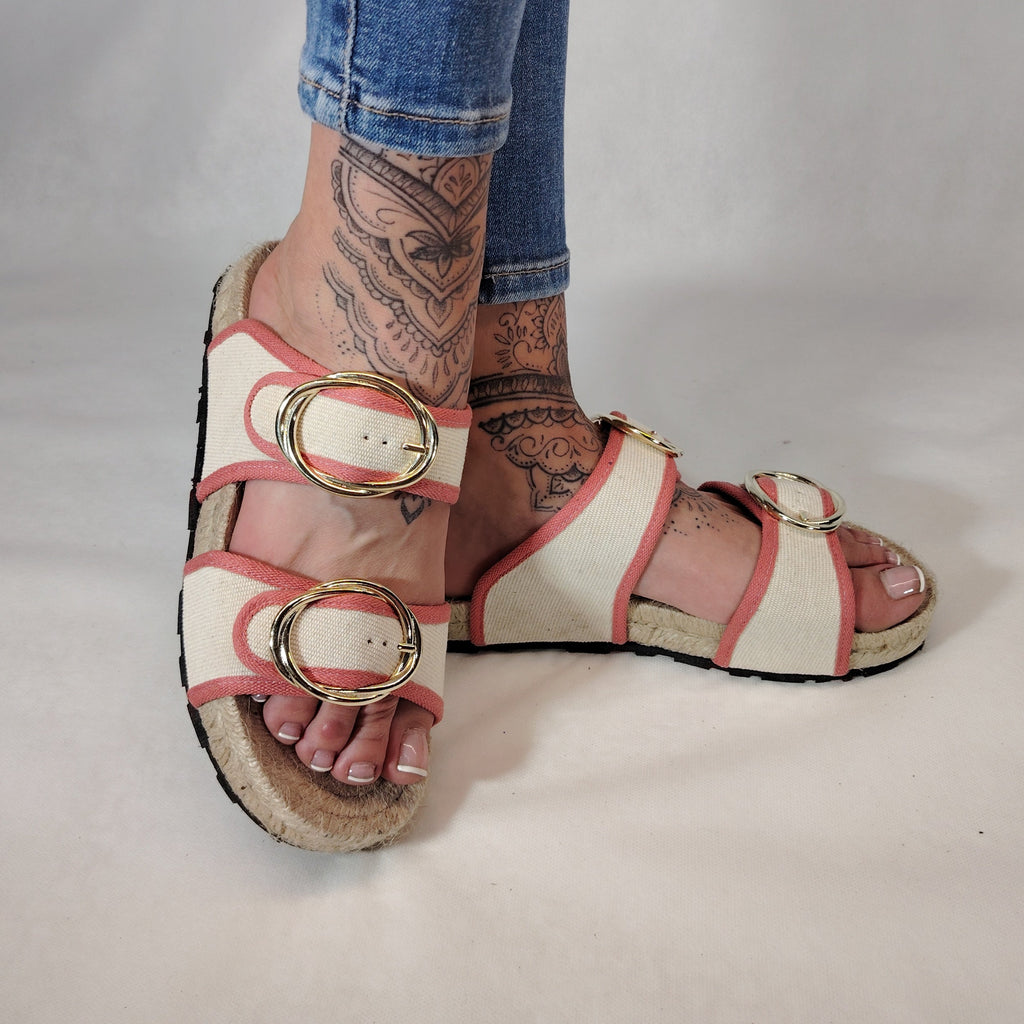 Sandalia plana de yute natural con corte en tejido color blanco y detalles en rosa con 2 hebillas y diseño artesanal de verano.